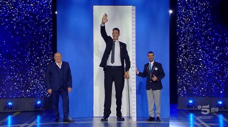 “Accanto a lui mi sento come Magalli”, così Gerry Scotti ha presentato l’uomo più alto al mondo, 2,5 metri!
